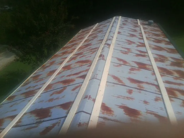 Rusted metal roof panels with new wood purlins before replacement — Storm Damage Roof Repair in Saint Helens by Roofing Brothers