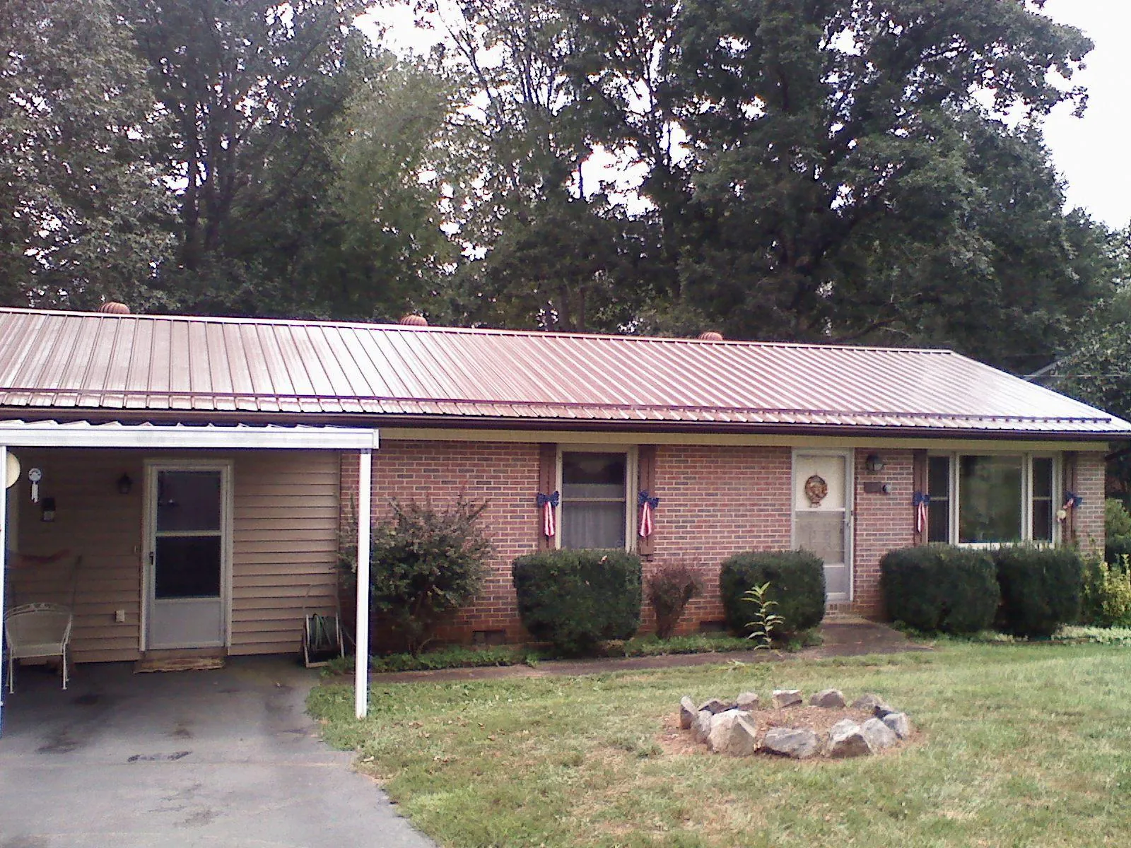 Bronze metal roof and carport on a brick ranch home — Roof Repair work by our crew in Saint Helens